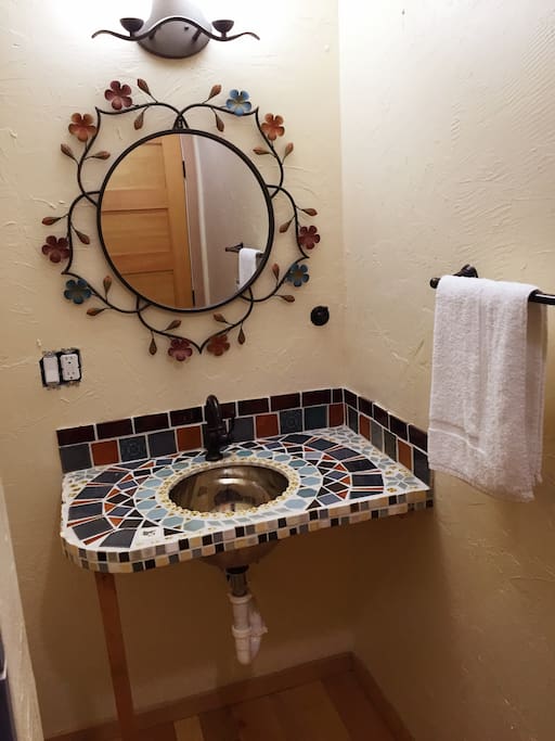 Hand tiled sink counter in the bathroom.