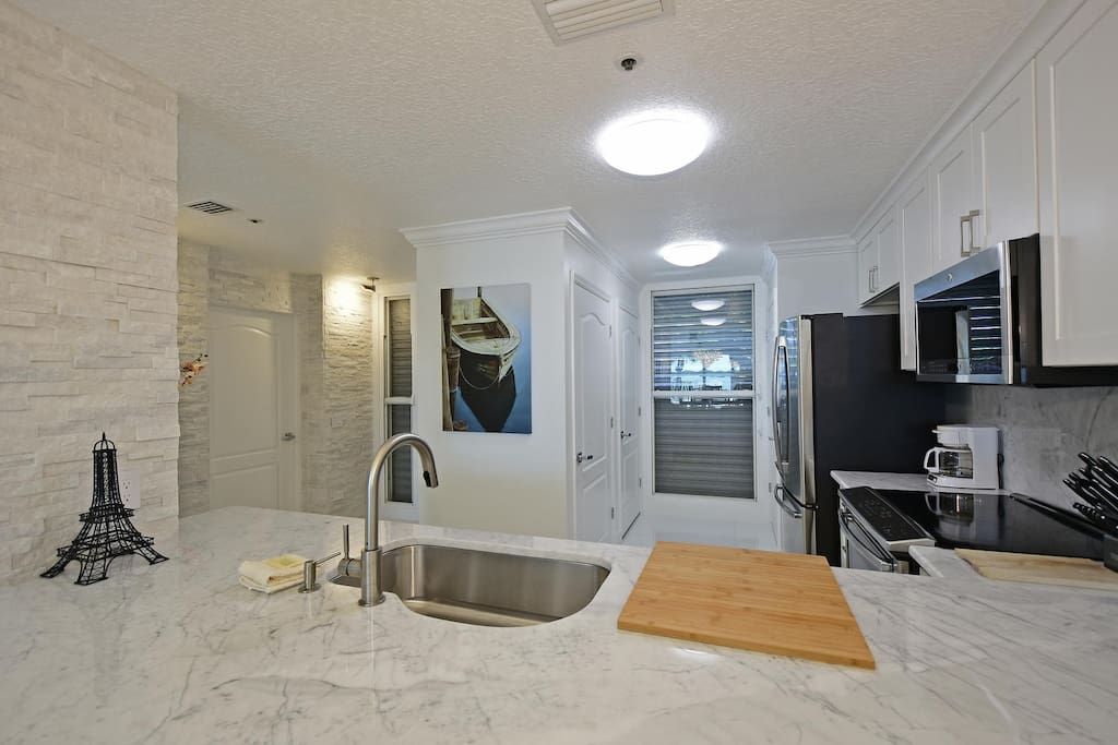 Wide kitchen with vibrant lighting.