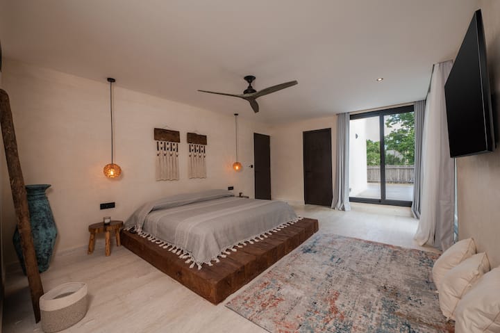 Master bedroom on the second floor, with a king size bed, private bathroom, and acces to the terrace overlooking the pool.