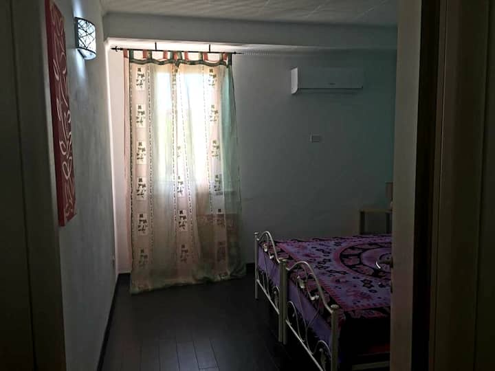 Chambre avec climatisation et grande fenêtre.