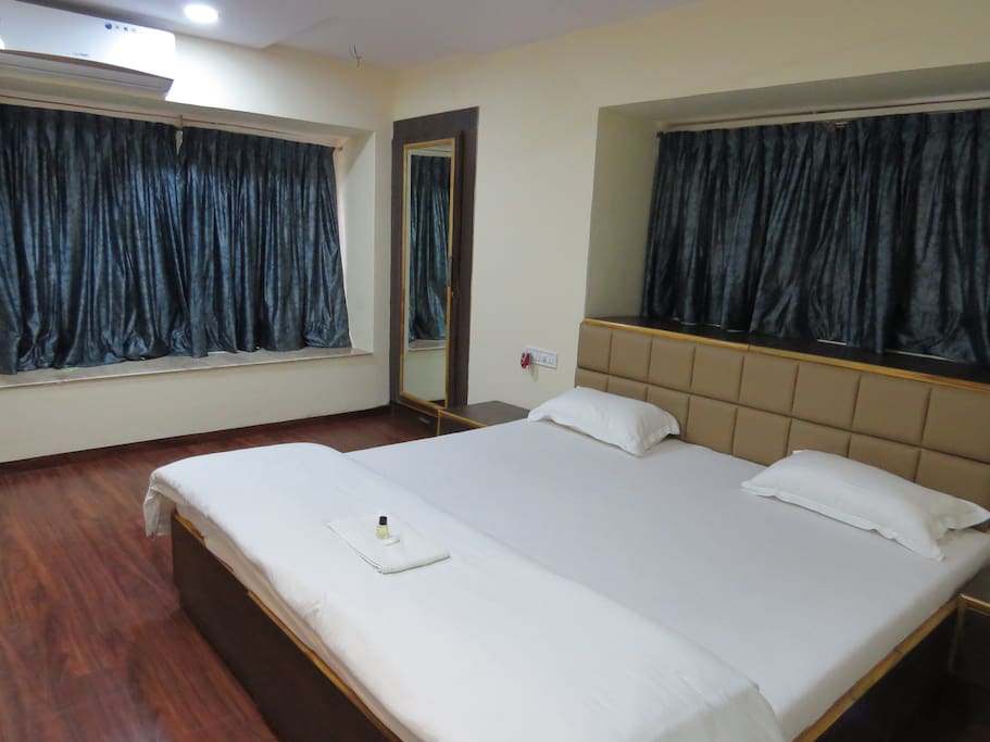 Spacious and modern studio aircon room with a king sized bed and concealed wardrobe.