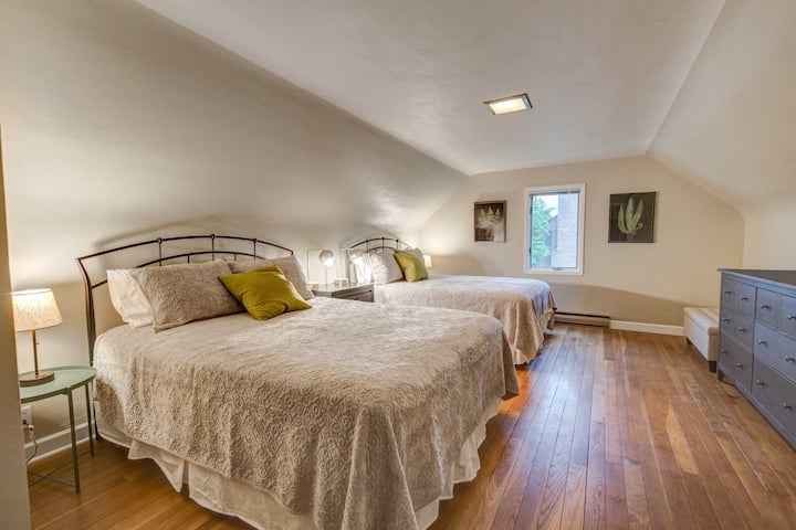 חדר שינה מרווח למעלה עם 2 מיטות קווין סייז וחדר אמבטיה צמוד.