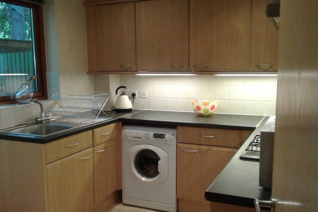 Kitchen with washing machine, oven and hob