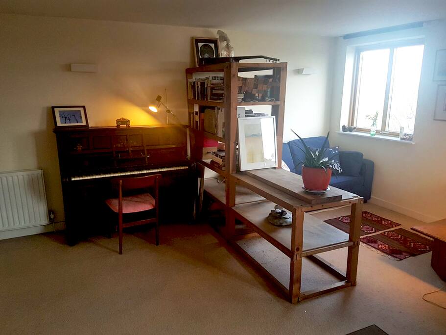 A piano and a cosy little seating area. The sofa turns into a comfortable bed for two.