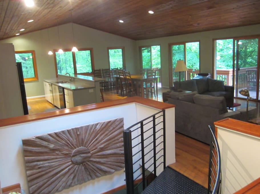 Open concept great room with kitchen, dining room, living room with fireplace, and spacious decks