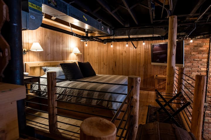 Another sleeping loft like space with king bed and tv.