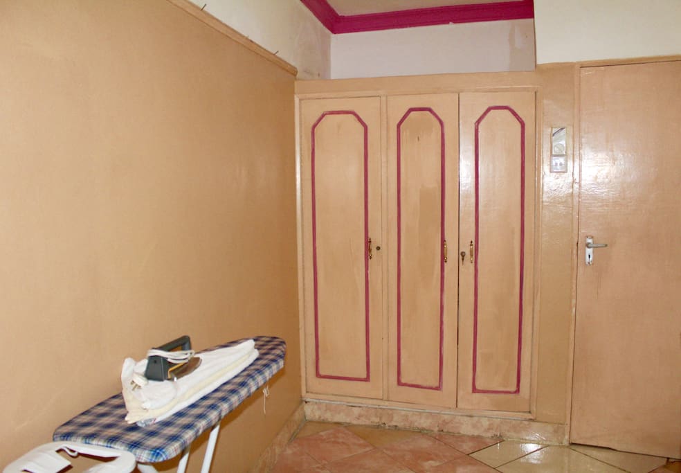 Ironing table and a huge wardrobe with hungers and bedsheets