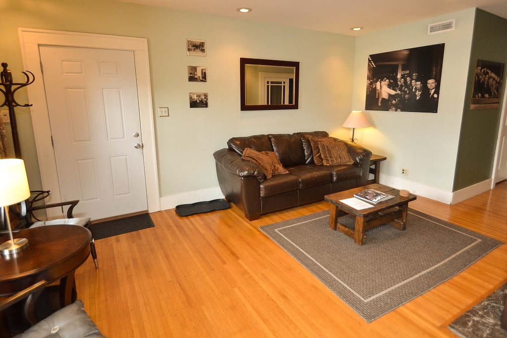 Spacious living room with quality wood furniture, a leather couch and internet connected 48" TV.
