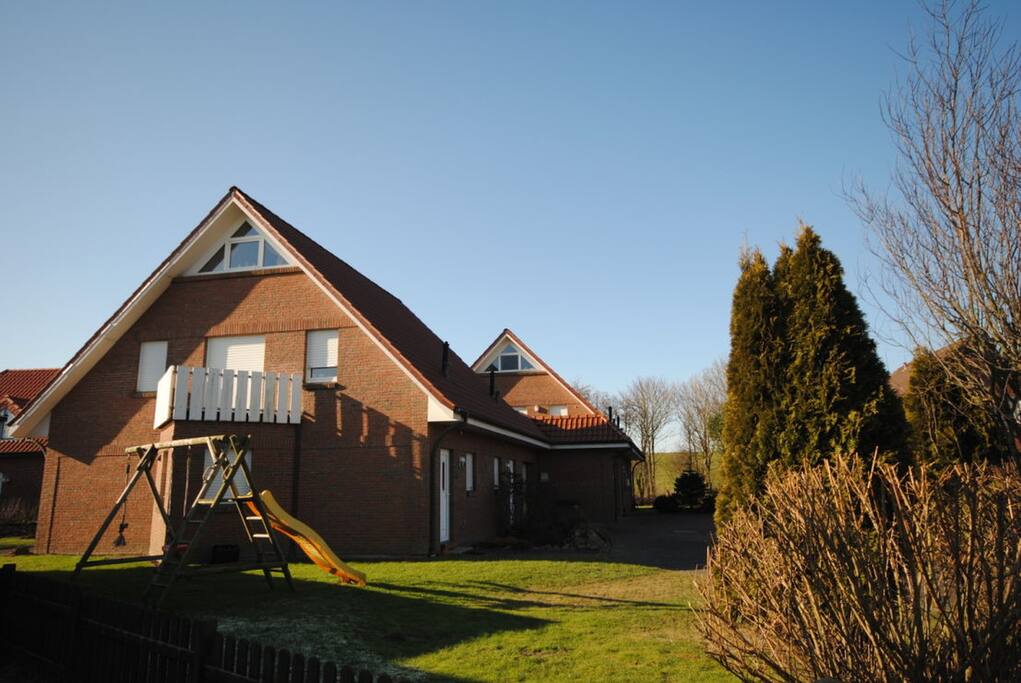 Hausansicht mit Deich im Hintergrund