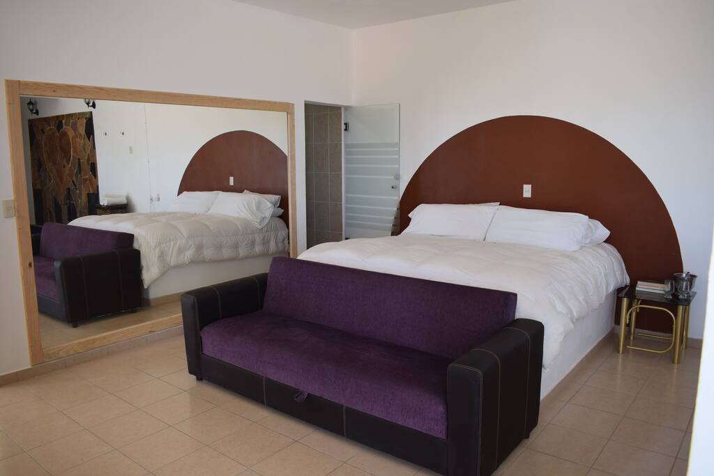 Cama king size con edredón de 3,000 hilos; Sofa cama frente a la televisión; Espejo de toda la pared; Puerta del baño de cristal. Interruptores de luz en la cabecera.