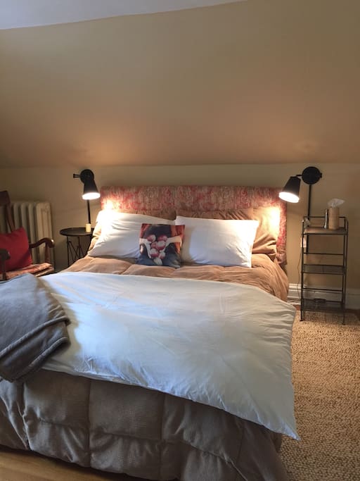 Queen-sized bed in larger room of two; note that bedding may vary seasonally.
