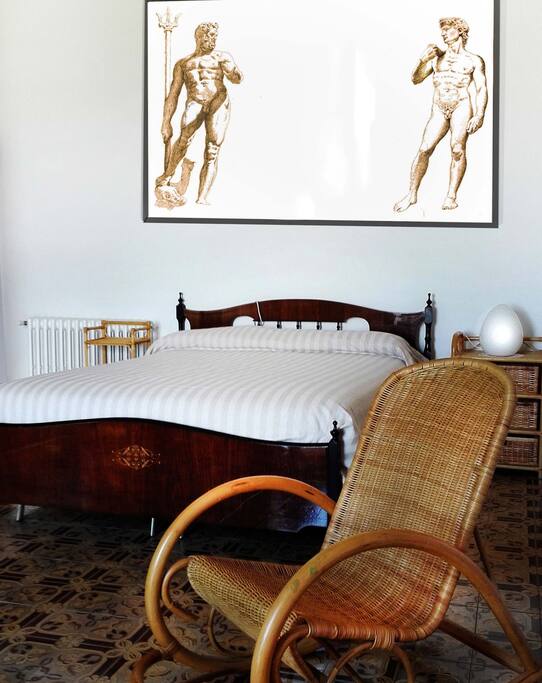 Spesso le opere all'interno della Casa degli Dei vengono sostituite. Si tratta di opere dell'Artista Walter Materassi che danno un tocco personalissimo ad ogni singola stanza e all'ambiente dell'intera casa. Prima delle ultime modifiche c'era questo disegno sopra al grande letto matrimoniale, rappresenta da un lato la statua del Nettuno (icona di Bologna) dall'altra il David di Michelangelo ( icona di Firenze). Le due città, tra le più importanti del rinascimento sono i nostri punti di riferimento geografico e culturale da sempre. Siamo immersi nelle foreste dell'Appennino a 45 minuti da Firenze e Bologna. La nostra cucina, i nostri dialetti, la nostra cultura risente da sempre dell'influsso di queste due meravigliose città a 45 minuti da qui.