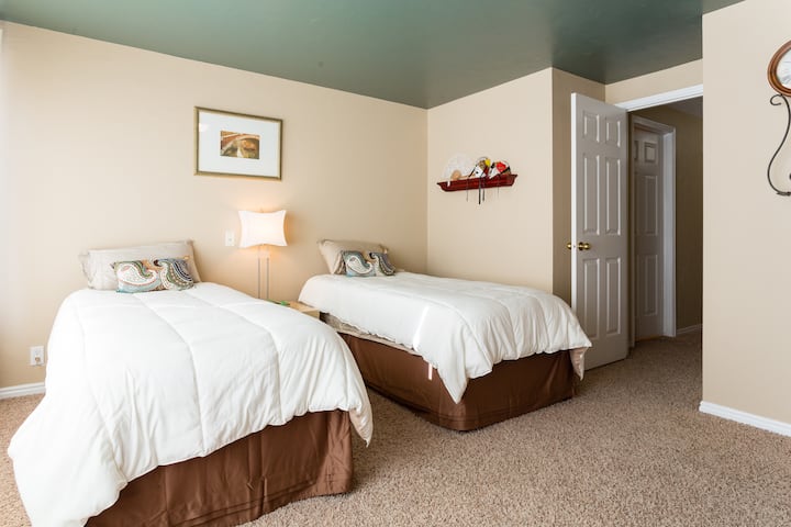 Zeer ruime slaapkamer met 2 extra lange eenpersoonsbedden en 1" traagschuim bovenop matras, mooi beddengoed en naar keuze kussen.  Het thema van deze kamer is na KJ's jaren van verblijf in Italië. Er zijn 2 bureaus met een ergonomische stoel met papiervernietiger