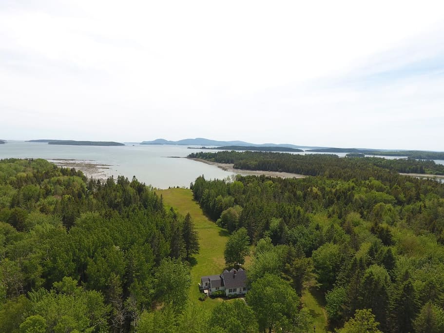 View of the house, yard, field, meadow, cove, bay, Mt. Desert Island and Cadillac Mountain.