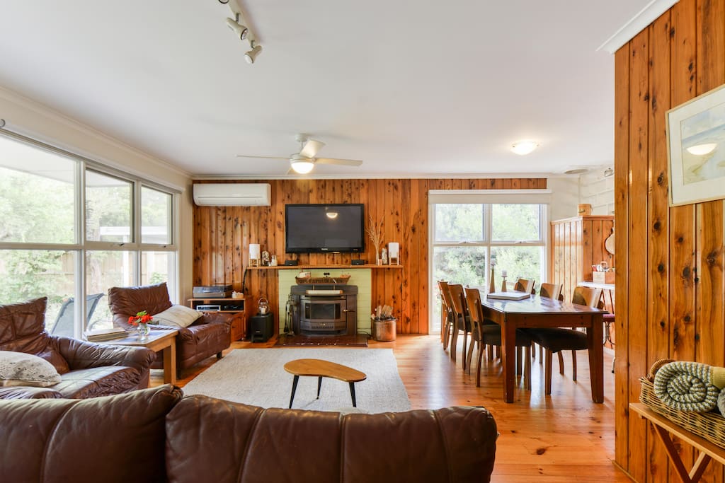 Enjoy the fireplace, AC and heating split system, large TV, record player, bose speakers, cupboard full of DVDs, DVD player, and large dining table, all in an open plan, light filled rom.