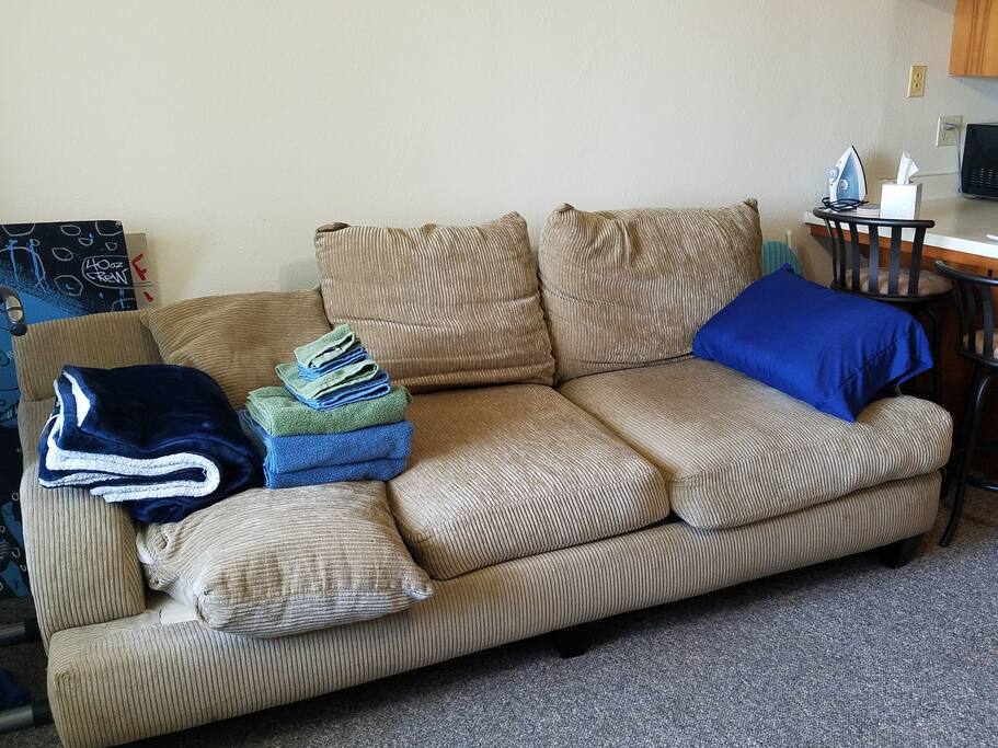 Plush corduroy sofa with pillow and soft blanket