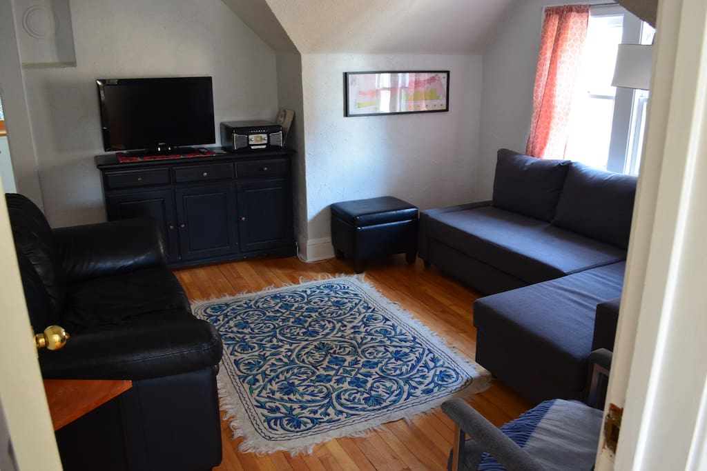 Large living room with pull out queen size bed, love seat and tv.