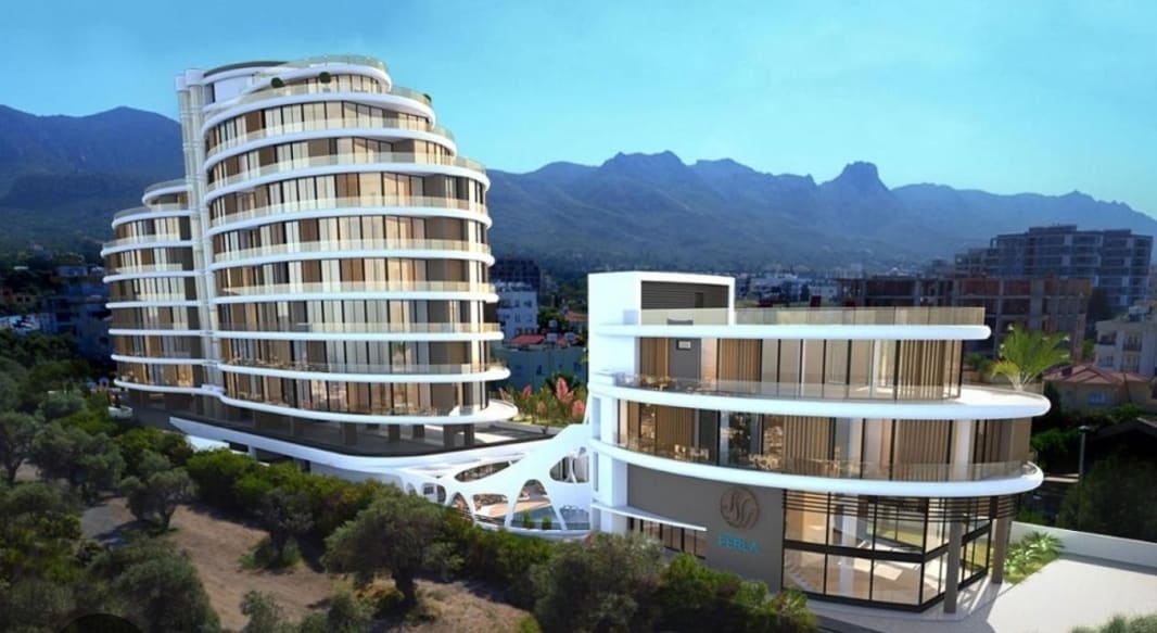A modern luxury residence is displayed with a unique design, featuring multiple curved levels. Large glass windows reflect the surrounding mountains, enhancing the architectural appeal. Lush greenery is visible in the foreground, providing a serene contrast to the sleek building structure.