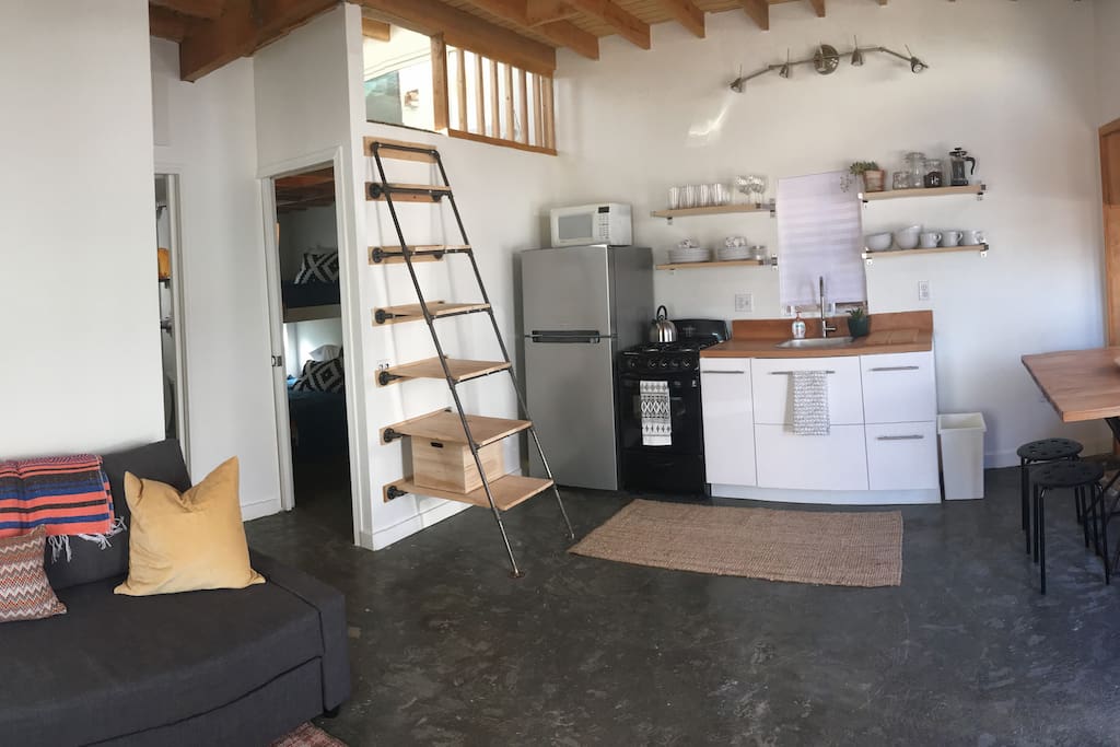 The stairs leading up to the loft double as shelves to store your kitchen or personal items.