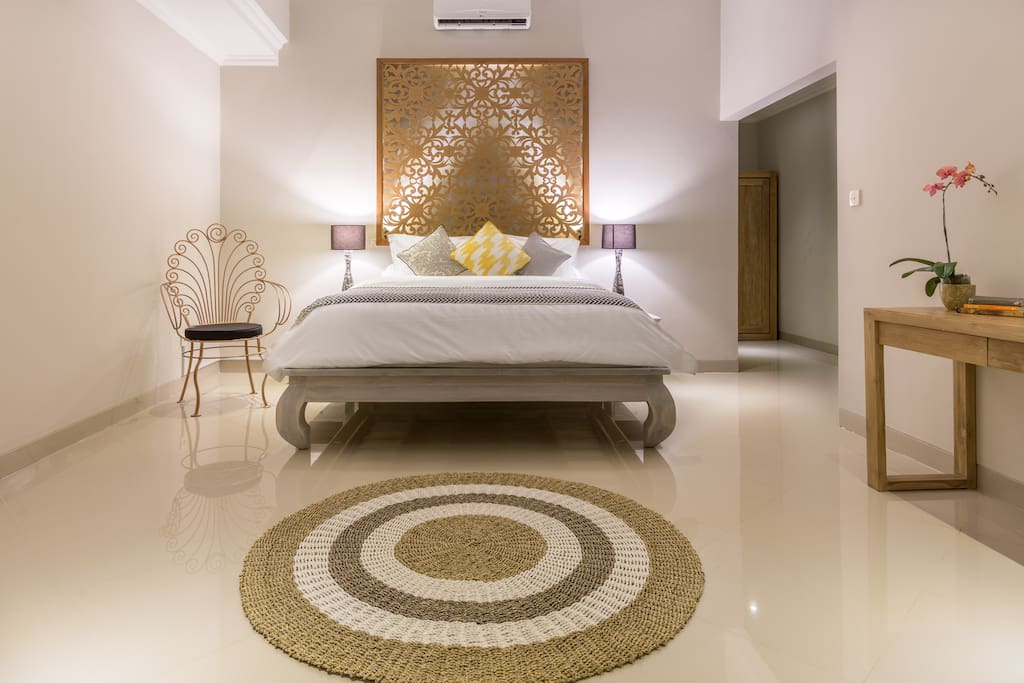 The First Grand Master bedroom boasts a blend of Balinese teak and modern furniture with a backlit headboard designed and hand carved exclusively for Gratitude Villa. Generously sized with high ceilings, all bedrooms contain full block out curtains for optimal jet lag recovery and extra privacy.