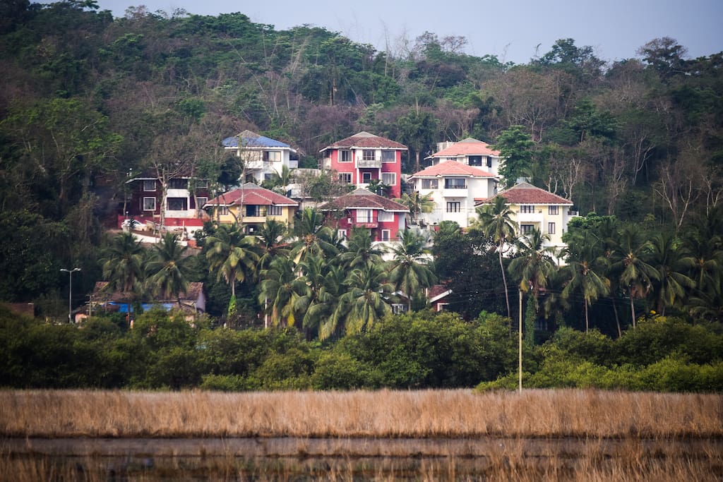 Nestled on a hillside in a small gated community surrounded by lush woodland overlooking the backwaters of the Mandovi