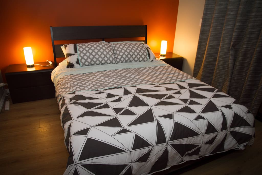 Large bedroom with queen bed, BIR, balcony access and mountain views.