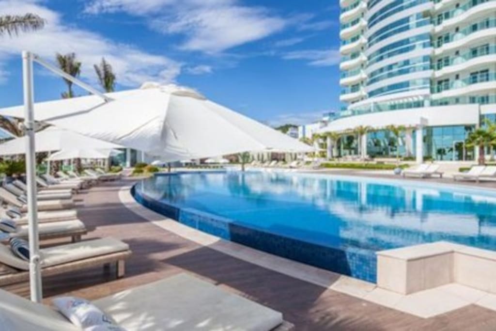 Detalhe da piscina e espreguiçadeiras de frente para o mar