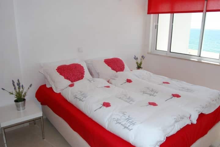 חדר שינה ראשי עם נופים יפים של הים.