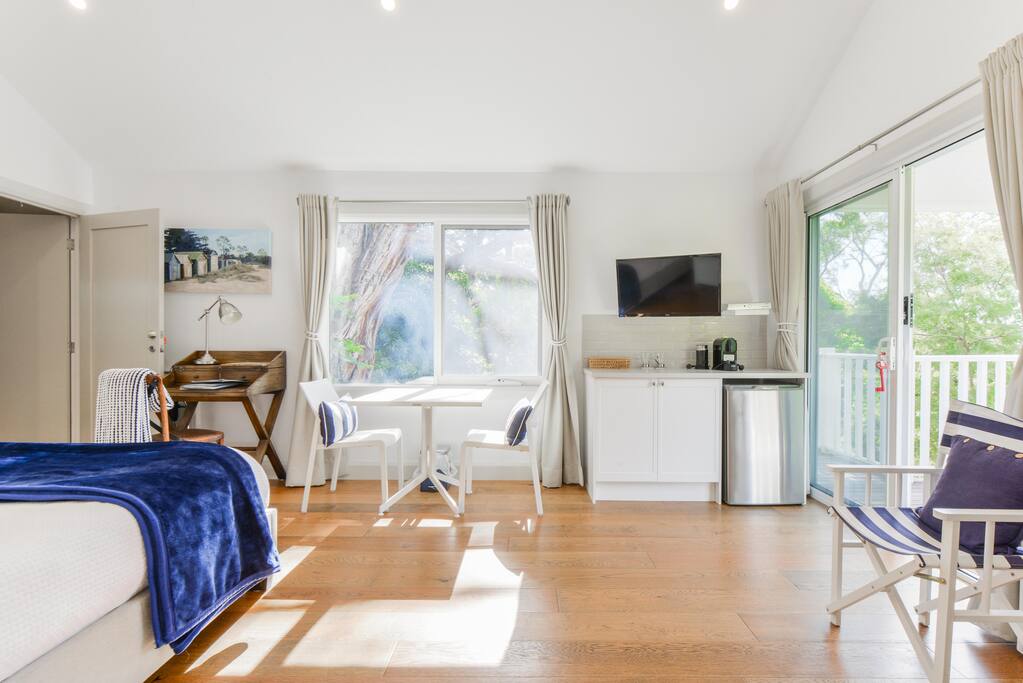 Regatta queen bed studio guest suite is light filled and spacious with vaulted ceilings and treed outlook.