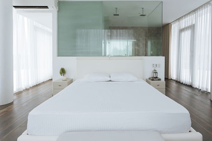 Master bedroom with king size bed and complete toilet at the back with two head showers.