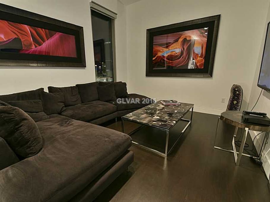 Lounge room with 70" TV and black velvet sofa.