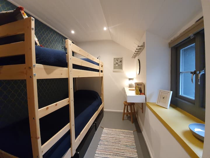 Our super comfortable twin room has adult sized bunk beds and views over the read garden.