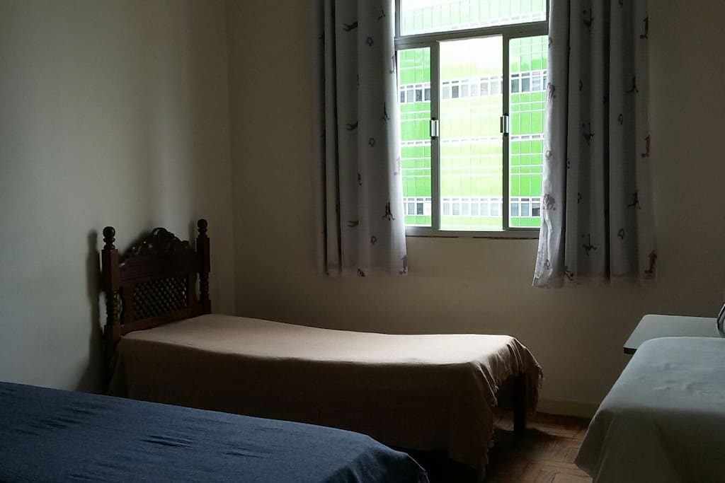 Quarto de solteiro com duas camas.