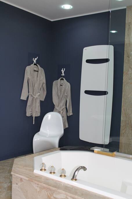 grande salle de bain équipée de baignoire et douche