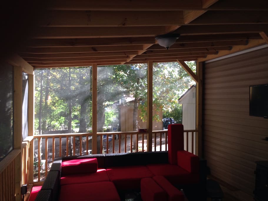 Nature view from screened in porch with living room and TV.