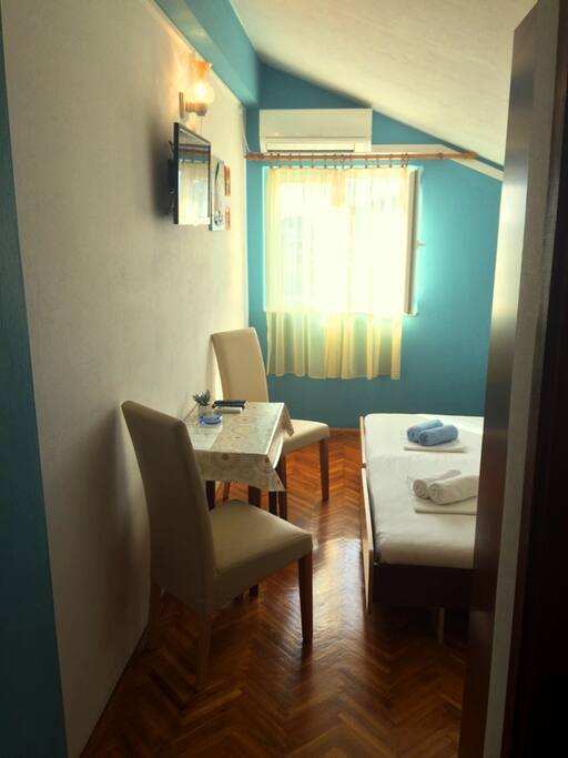 Table with chairs, TV+SAT opposite the bed..