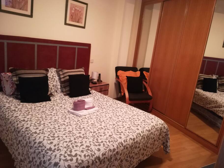 desde la entrada se aprecia la cama y el armario empotrado de cuatro puertas con cajones por dentro