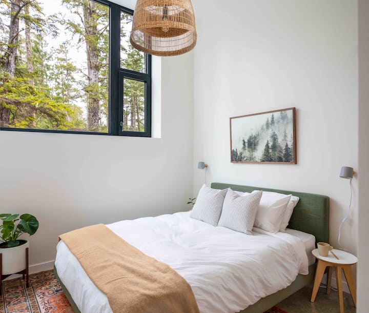 Wake up to the forest—the serene second bedroom features a plush Queen bed, luxe Brooklinen bedding, full closet, and soft morning light filtering through the trees