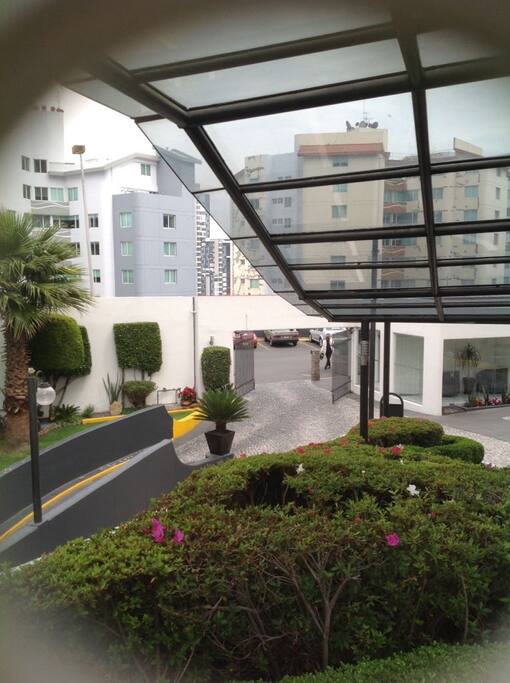 Jardín y áreas comunes cuidadas con canchas de tenis, piscina y gumnadio