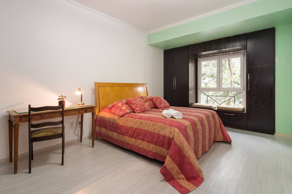 vista geral da suíte, com mesa de trabalho e cama queen size