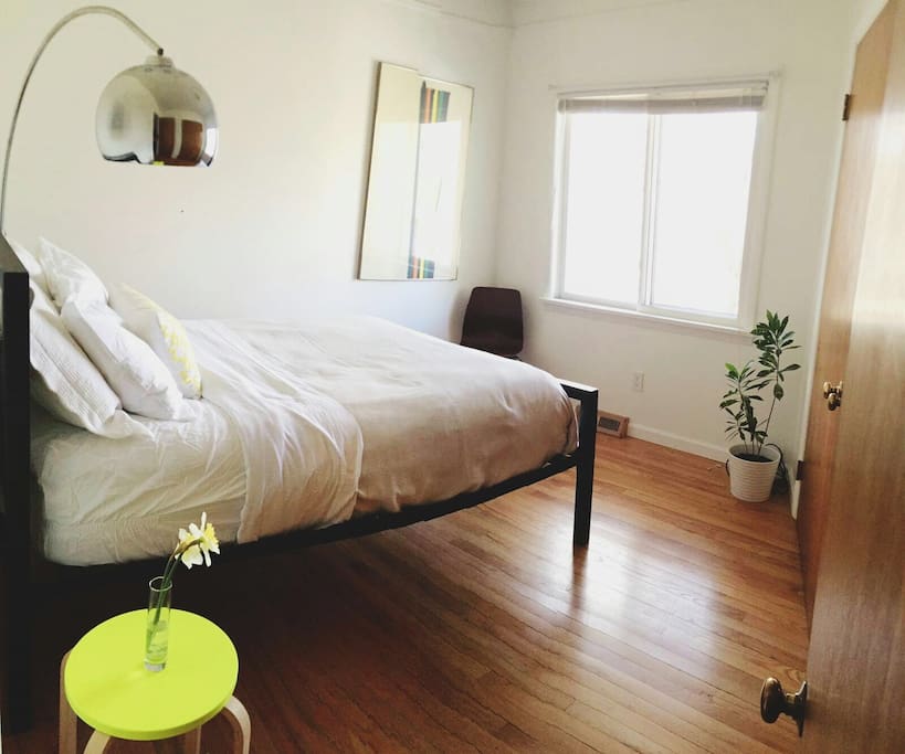 Private & cozy bedroom with a full-size bed, comfortable pillows & soft sheets, & marble/steel industrial lamp.