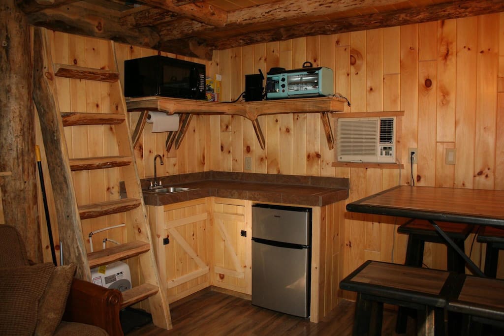 Kitchen equipped with a sink, microwave,refrigerator, griddle, coffee pot,hot plate and crockpot.