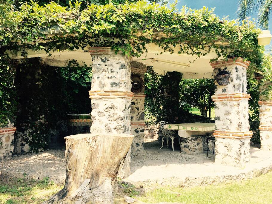 es una foto de la palapa donde se alcanza a ver un poco el asador y el comedor a un costado de la alberca.