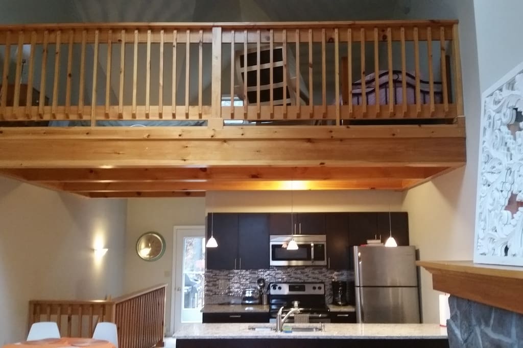 Looking into kitchen from great room, loft above with two beds.