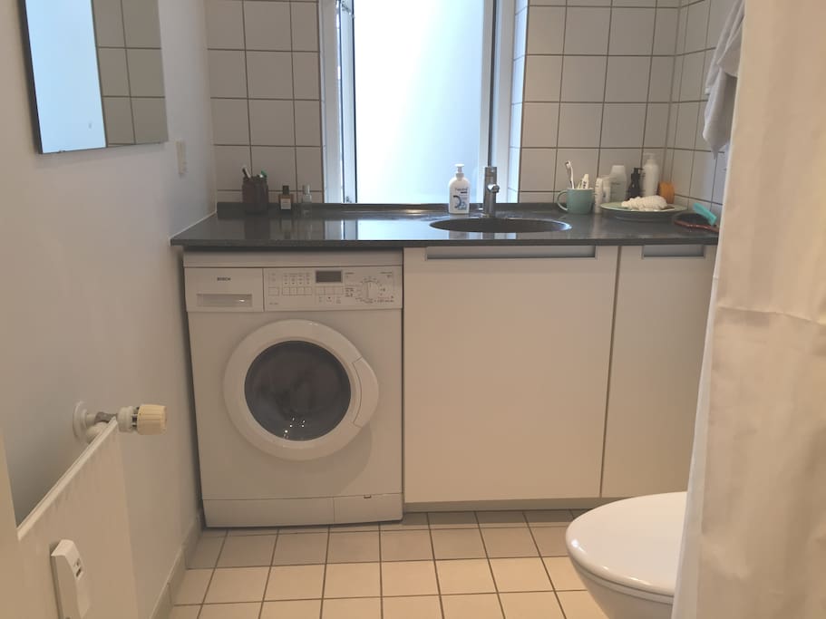 spacious bathroom with washing machine.