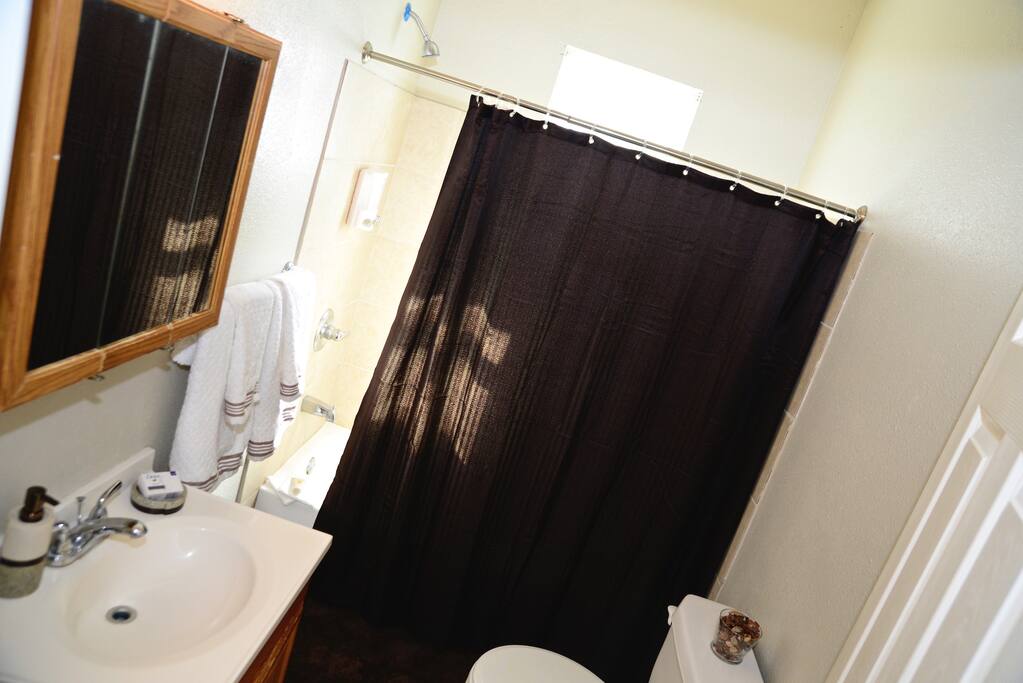 Tub Shower Combo bathroom supplied with towels, soap, and lotion