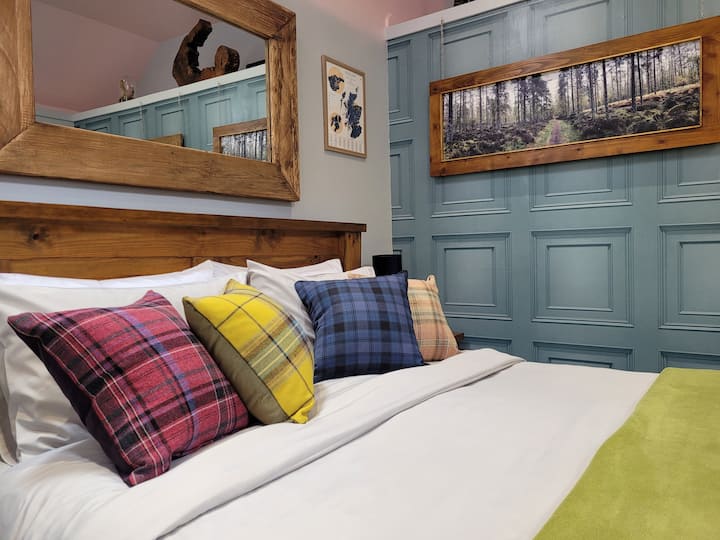 Furahia starehe ya mito ya tartan iliyotengenezwa kwa mikono huku ukiangalia picha za misitu ya eneo husika.