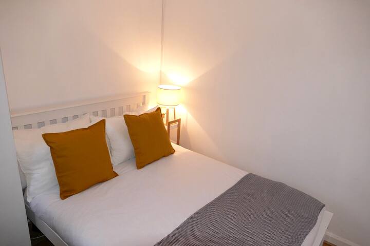 Dormitorio 2 con una cama doble, almacenamiento debajo de la cama y ganchos colgantes.