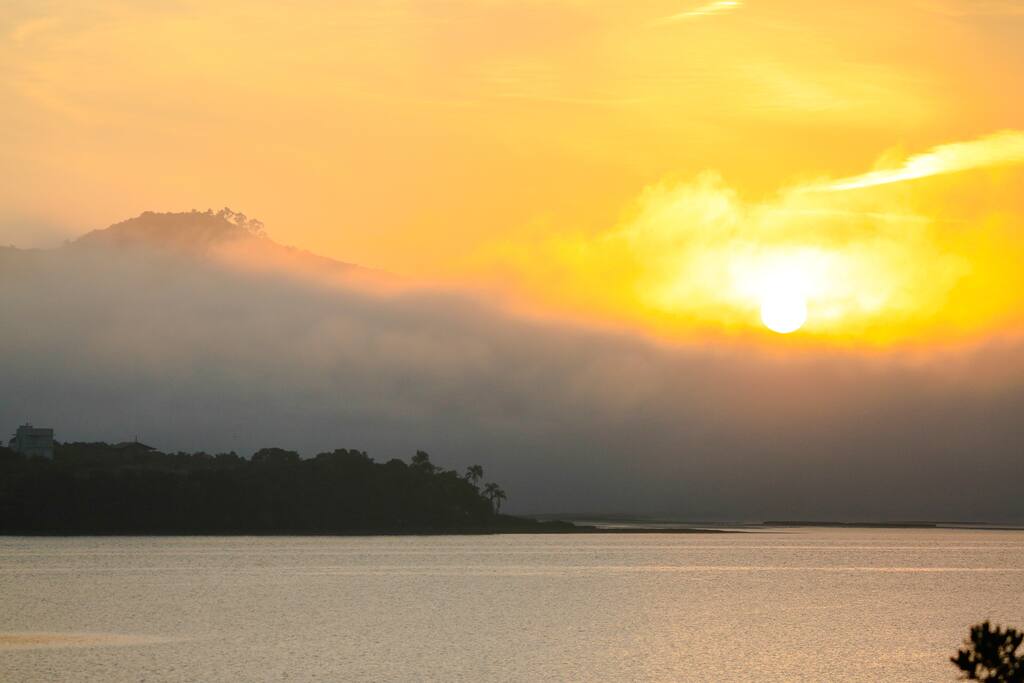 Visual do nascer do sol da janela do quarto.