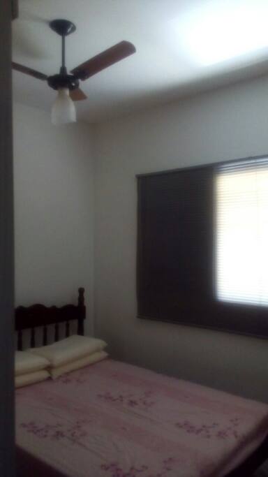 Quarto com cama de casal, guarda-roupa e ventilador de teto